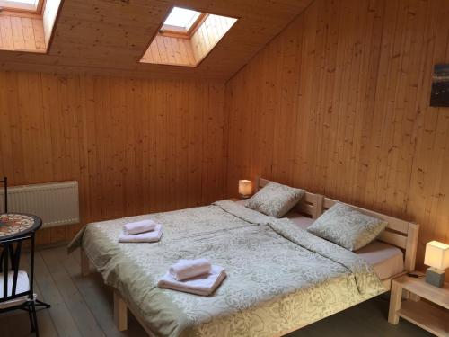 1 dormitorio con 1 cama con 2 toallas en Četri Vēji en Jūrkalne