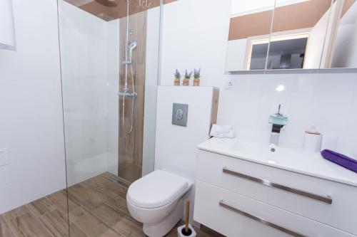 a white bathroom with a toilet and a shower at Lavanda in Kaštela