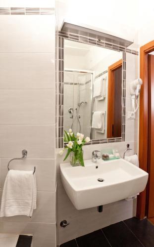 a bathroom with a sink and a mirror at Hotel Helvetia in Genova