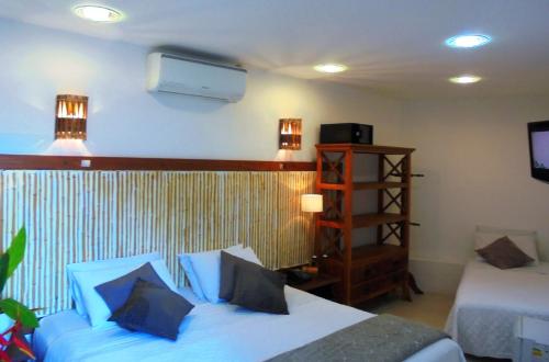 um quarto de hotel com duas camas e uma televisão em Pousada Náutilus em Ilhabela
