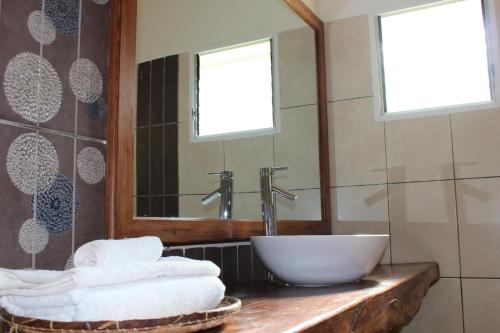 a bathroom with a sink and a mirror and towels at Riviera Garden in Antananarivo