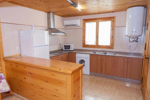 a kitchen with a white refrigerator and a sink at Casa Rural los Caños in Fuente-Álamo