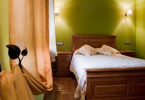 a bedroom with green walls and a bed with white sheets at Apartamentos Rurales El Fresnu in Silvamayor