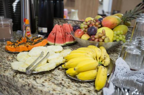un mucchio di banane e altri frutti su un bancone di Hotel Oitis a Governador Valadares
