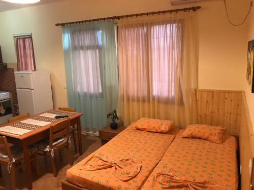a bedroom with two beds and a table and a desk at Guroal Holiday House in Shëngjin