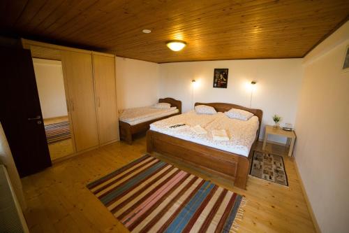 a bedroom with two beds and a wooden ceiling at Casa Hille in Măgura