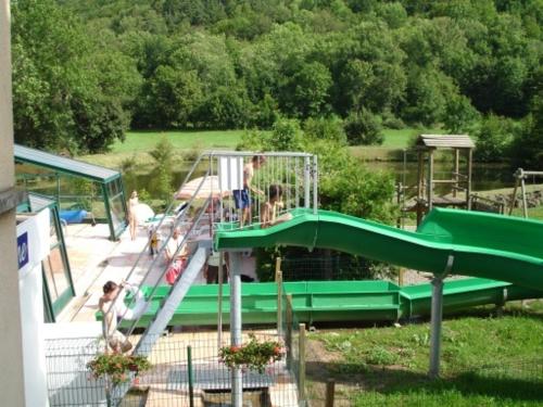 a group of people on a slide at a playground at Résidence Les Dômes in Murol
