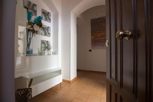 a hallway with a door and a vase of flowers at boutique apartment al duomo in Salerno
