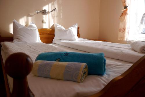 dwa łóżka z białą pościelą i niebieską torbą w obiekcie Apartamenty Klemens w mieście Puck