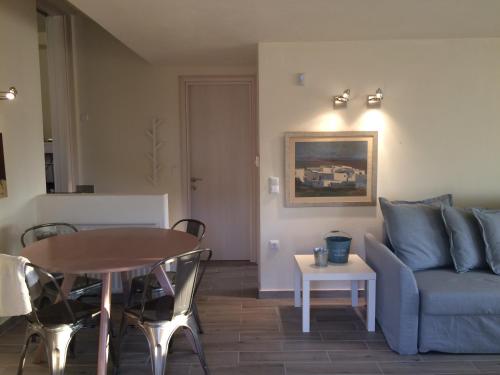 a living room with a blue couch and a table at Armonia Villas in Skala Rachoniou