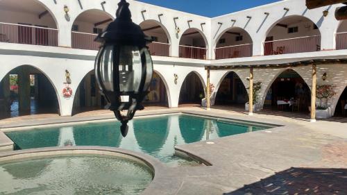 a building with a swimming pool in a courtyard at Hotel Hacienda Bugambilias in La Paz