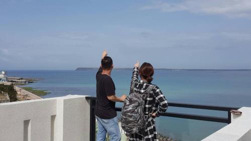 two people looking at the ocean from a ledge at Jia Xiang Lin Guan Hai Homestay 2 in Magong