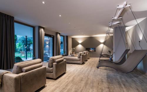 a living room with a slide and a couch and chairs at Hotel - Appartements Schmied Hans in Schenna