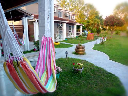 a house with colorful hammocks hanging from a porch at Demis Apartments in Sidari