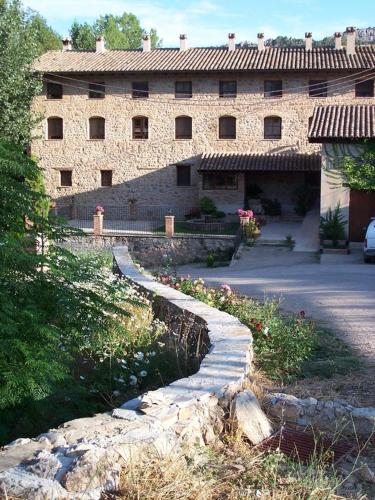 a large brick building with a walkway in front of it at Font del Pas in Beceite