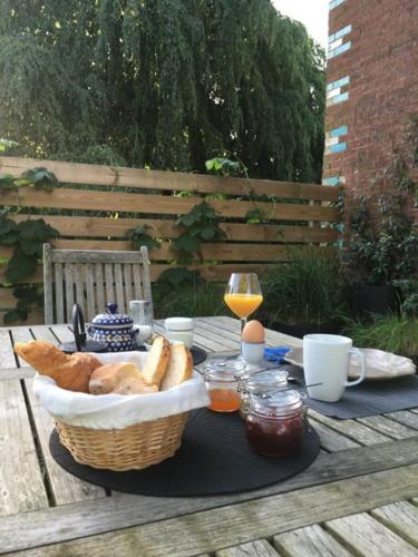 - une table de pique-nique avec un panier de pain et un verre de vin dans l'établissement Villa Marguerite - Chambres d'Hôtes, à Saint-Omer
