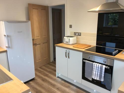 a kitchen with a refrigerator and a stove top oven at Exmouth holiday home in Exmouth