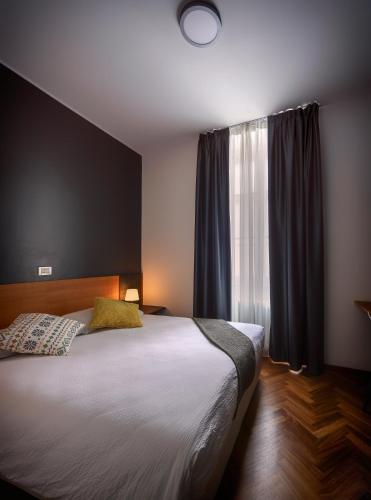 a bedroom with a large bed and a window at Lainez Rooms & Suites in Trento