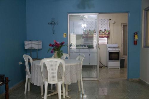 a dining room with a table and chairs and a kitchen at Cavernas Guest House in Quebrada
