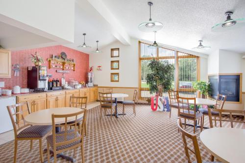 a room with tables and chairs and a kitchen at Super 8 by Wyndham Waverly in Waverly