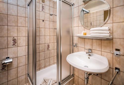 a bathroom with a sink and a shower at Hotel Linde in Collalbo