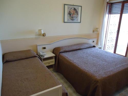 a hotel room with two beds and a window at Hotel Riviera in Trani