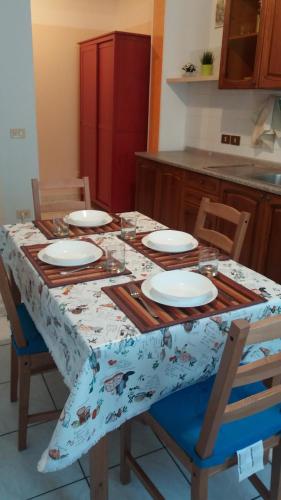 a table with chairs and plates on it in a kitchen at Residence Kimba in Rimini