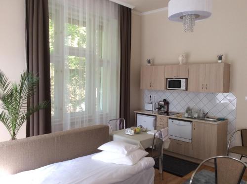 um quarto com uma cama e uma cozinha com uma mesa em Stefánia Stúdió Apartmanok em Szeged