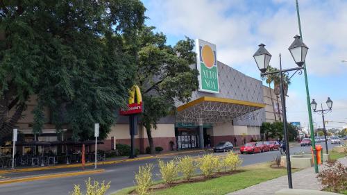 un restaurante McDonalds en una calle con coches aparcados en La Quinta Residencia en Salta