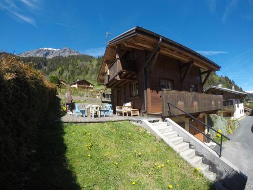 une cabane en rondins avec une cour gazonnée devant elle dans l'établissement Chalet Indépendant " L'anfian-ne", aux Contamines-Montjoie