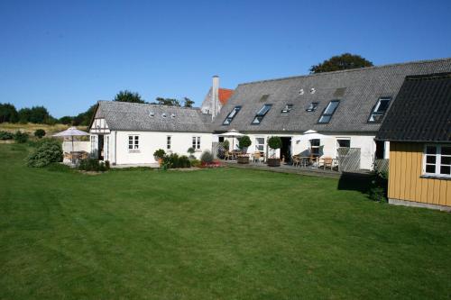 a large white house with a large yard at Rødkærgård Bed & Breakfast in Kerteminde