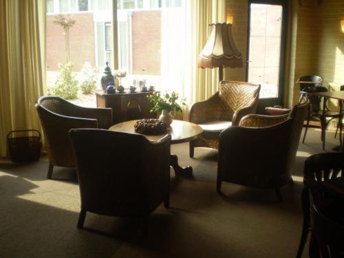 a living room with chairs and a table and a couch at Hotel & Restaurant 'T Holt in Diepenheim