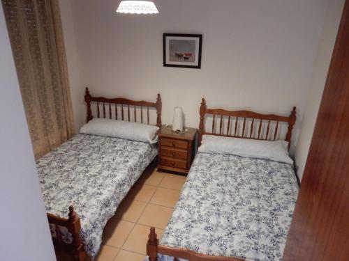 ValdelarcoにあるCasa Rural Valdecumbresのベッドルーム1室(ベッド2台、ナイトスタンド付)