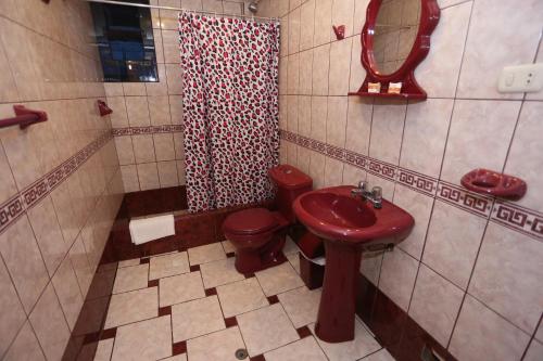 y baño con lavabo, aseo y espejo. en Totorani Inn, en Puno