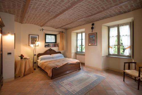 a bedroom with a bed in a room with windows at Hazelnut Valley in Guarene