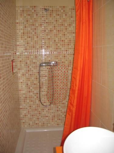 a shower with an orange shower curtain in a bathroom at Villa Casa do Monte in Silves