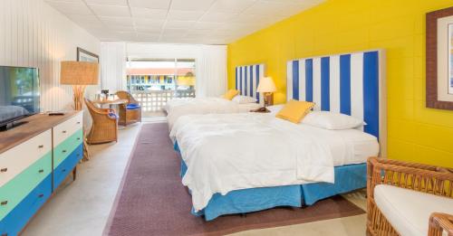 a bedroom with two beds and a yellow wall at Bimini Big Game Club Resort & Marina in Alice Town