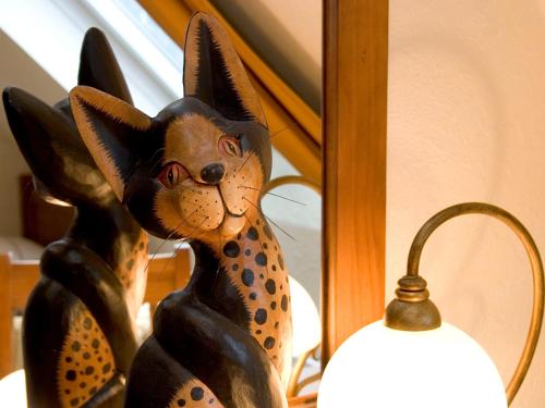a statue of a cat sitting next to a mirror at Landhotel Grimmeblick in Winterberg
