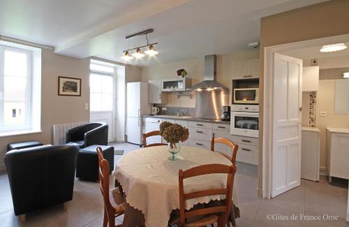 une cuisine et une salle à manger avec une table et une cuisine ainsi qu'une chambre dans l'établissement Gîtes de 