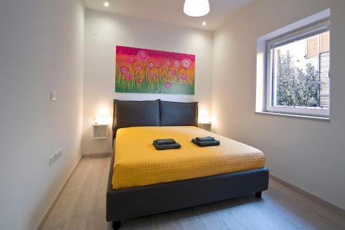 sypialnia z żółtym łóżkiem i obrazem na ścianie w obiekcie Holiday home M1 & M2 w Puli