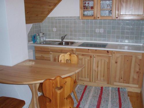 uma cozinha com uma mesa de madeira e um lavatório em Apartmaji Pr Potovcnk em Dovje