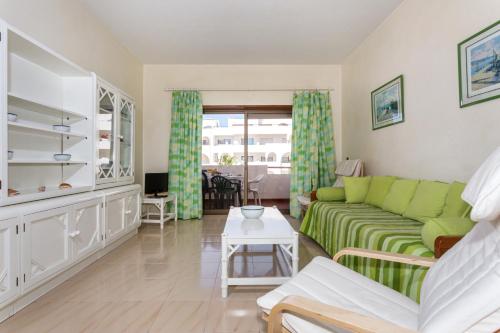 a living room with a green couch and a table at Andorinha 2 bedroom apart-close to the sea-Algarve in Porches