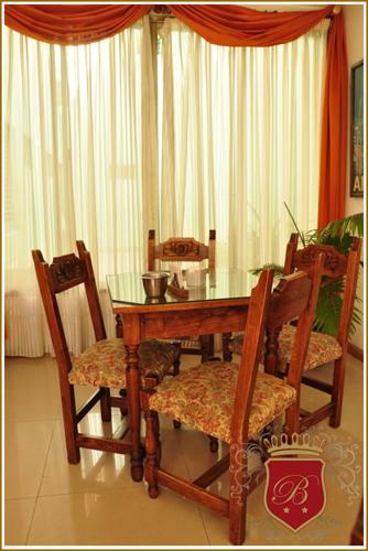 a dining room table and chairs with a glass table at Hotel Berlin in Gualeguaychú