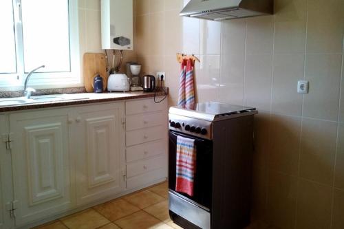 a kitchen with a stove and a counter top at Casa do Moinho in Santa Cruz