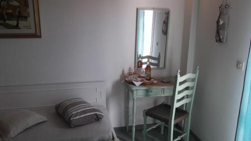 a bedroom with a bed and a mirror and a chair at Eros Beach Hotel in Benitses