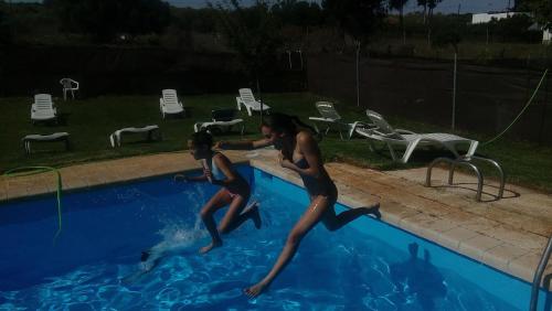 two women jumping into a swimming pool at Los Duendes in El Puerto de Santa María
