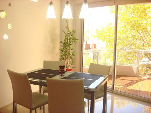 comedor con mesa, sillas y ventana en Rent Apart Caballito 3 en Buenos Aires