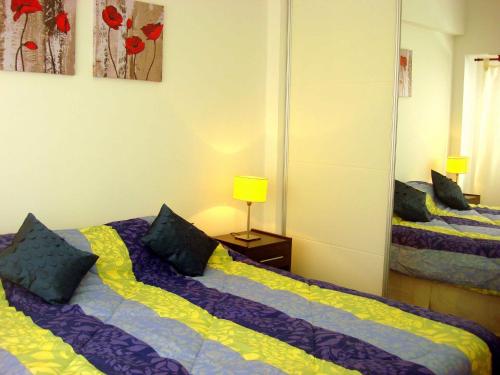 1 dormitorio con 2 camas y espejo en Rent Apart Caballito 3 en Buenos Aires