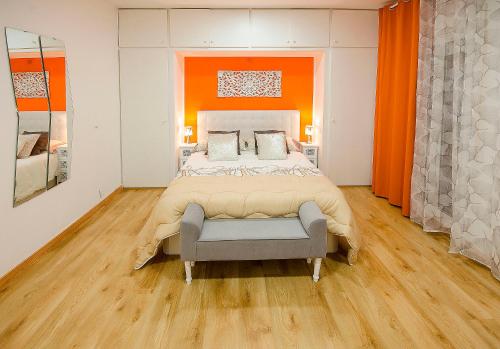 シッチェスにあるOscar Apartments Estaciónの大きなベッドとオレンジ色の壁が備わるベッドルーム1室が備わります。