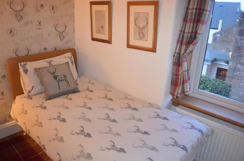a bed in a room with a pillow and a window at Roseneath Guest House in Inverness